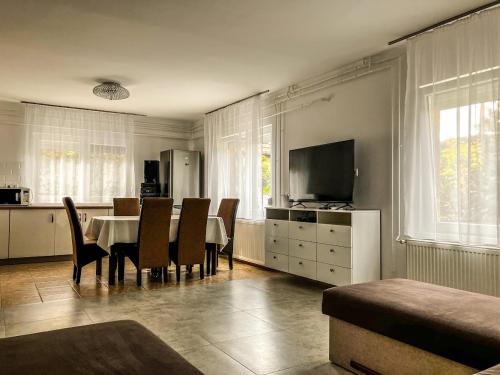 比克克塞克的住宿－Harmónia Vendégház Bükkszék，一间带桌椅和电视的用餐室