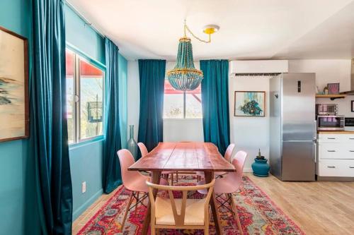a dining room with a wooden table and chairs at KAMPINK! Pool, Spa, Gameroom Compound with Amazing Views on 2.5 Acres in Joshua Tree