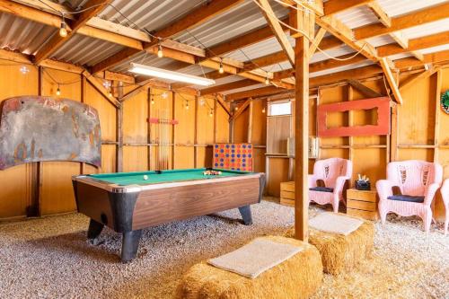 a room with a pool table and two chairs at KAMPINK! Pool, Spa, Gameroom Compound with Amazing Views on 2.5 Acres in Joshua Tree