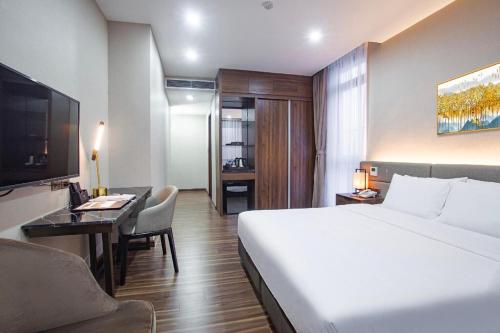 a hotel room with a large bed and a desk at Western Skyline Hotel - Số 2 Đại Lộ Thăng Long - by Bay Luxury in Hanoi
