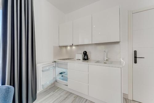 a kitchen with white cabinets and a sink at BAL Apartments Adults Only in Arona