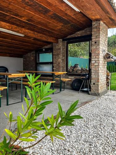 a patio with a table and chairs and a large window at Harmónia Vendégház Bükkszék in Bükkszék