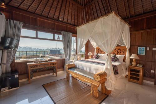 ein Schlafzimmer mit einem Himmelbett in der Unterkunft Barong Bali Resort Ubud in Ubud