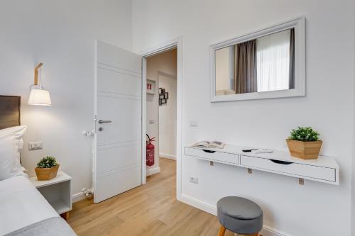 a white bedroom with a desk and a mirror at Colonna Luxury Apartment in Rome