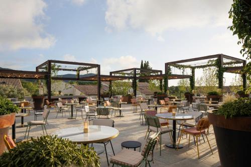拉加尔代弗雷纳Ultimate Provence Hotel & Spa的户外庭院配有桌椅和树木。