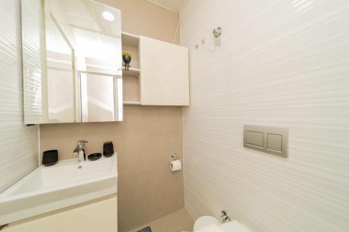 a bathroom with a white toilet and a sink at Residence w Shared Pool 3 min to Mall of Antalya in Antalya