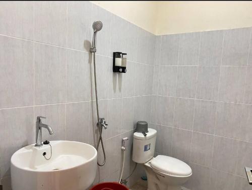 uma casa de banho com um lavatório, um WC e um chuveiro em Amadeo Guest House em Ratodena