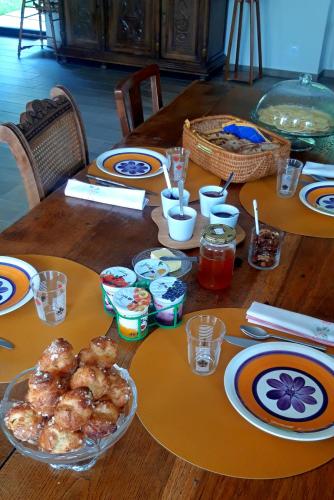 ein Tisch mit Tellern und Schüsseln mit Essen darauf in der Unterkunft Les jardins de Nanine in Lapleau