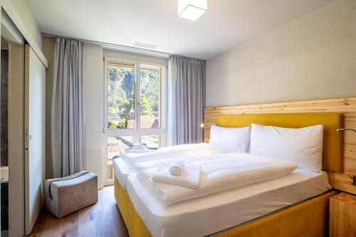 a bedroom with a large bed with a window at SWISSPEAK Resorts Meiringen in Meiringen