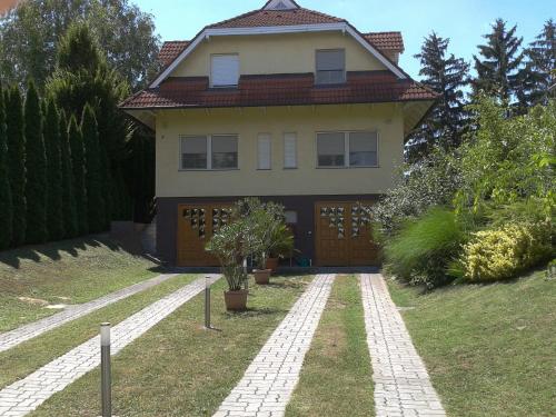 a house with a walkway in front of it at Roni Ház in Siófok
