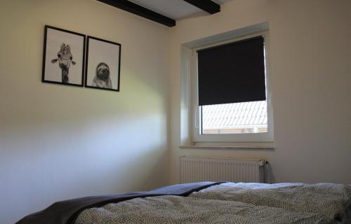 a bedroom with a bed and a window at Ferienhaus Strandnah - Wohnung 1 in Otterndorf