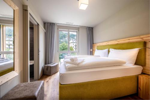 a bedroom with a large bed and a window at SWISSPEAK Resorts Meiringen in Meiringen