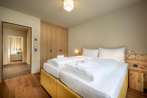 a bedroom with a large white bed with towels on it at SWISSPEAK Resorts Meiringen in Meiringen