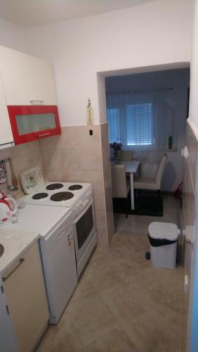 a kitchen with a stove and a living room at Center Una Apartment in Bihać