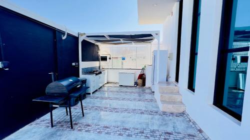 蘇爾的住宿－Wadi Shab Beach Villa，一间设有蓝色椅子和厨房的房间