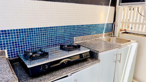 a kitchen counter with a stove and a sink at Wadi Shab Beach Villa in Sur