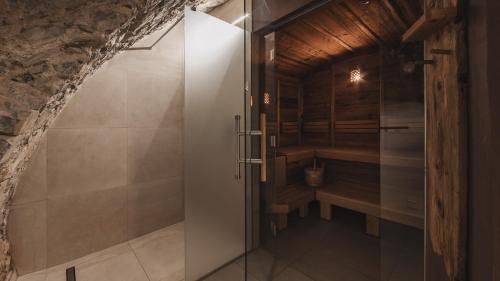 a bathroom with a shower and a bench in a room at Aparthotel Ansitz Felsenheim in Lermoos