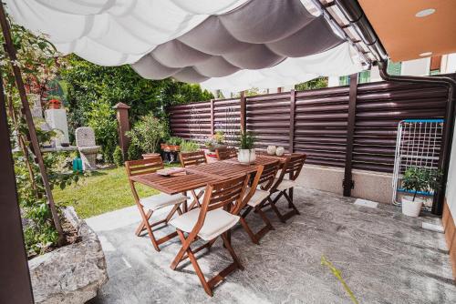 a patio with a wooden table and chairs at Gotar Apartment with Garden in Kobarid