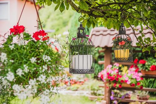two bird cages with flowers in a garden at Gotar Apartment with Garden in Kobarid