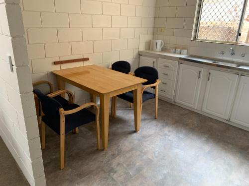 cocina con mesa de madera y sillas en Harbour View 49 Urch Street Unit 7 en Geraldton