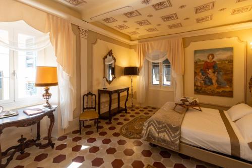 a bedroom with a bed and a desk and a window at Palazzo Lari Luxury Accommodation in Sarzana