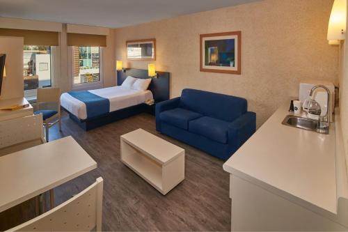 a hotel room with a bed and a blue couch at City Express by Marriott Puebla Angelopolis in Puebla