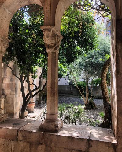 an archway with a column in a courtyard with trees at Casa Valerio in Conversano