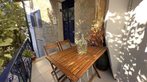 a vase sitting on a wooden table on a balcony at The Dolls House in Aldeia de João Pires