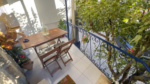 balcón con mesa de madera, sillas y plantas en The Dolls House en Aldeia de João Pires