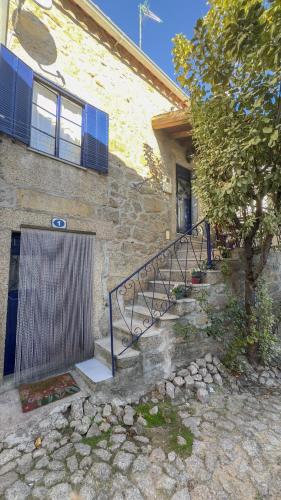 a building with a gate and a tree in front of it at The Dolls House in Aldeia de João Pires