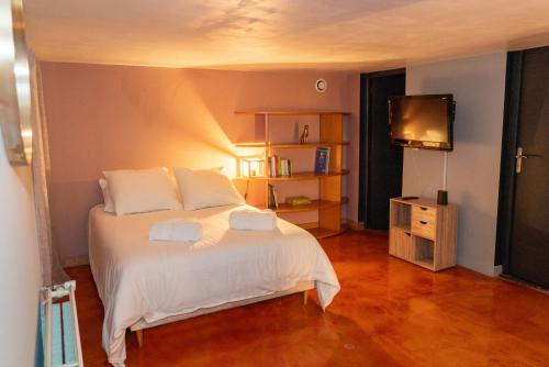 1 dormitorio con 1 cama blanca y TV en The Cosy Loft, en Dunkerque