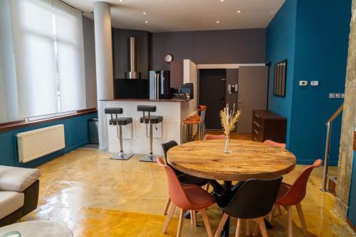 un salon avec une table et des chaises en bois dans l'établissement The Cosy Loft, à Dunkerque