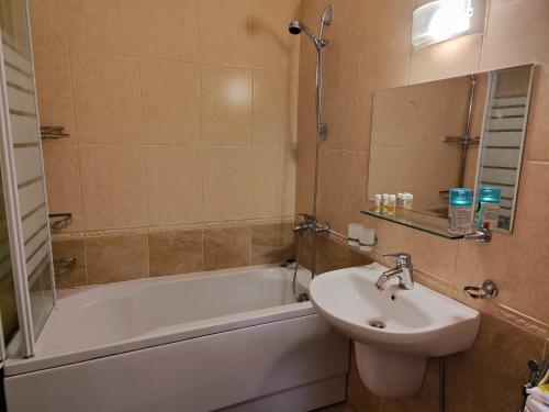 een badkamer met een wastafel, een bad en een toilet bij Апартамент "Red&Black" в Гранд Манастира - Пампорово in Pamporovo