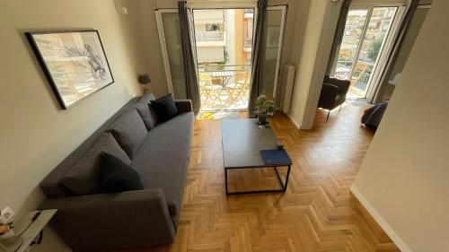 a living room with a couch and a table at 4 Newly Renovated Charming Apartments steps from Panormou Metro Station in Athens