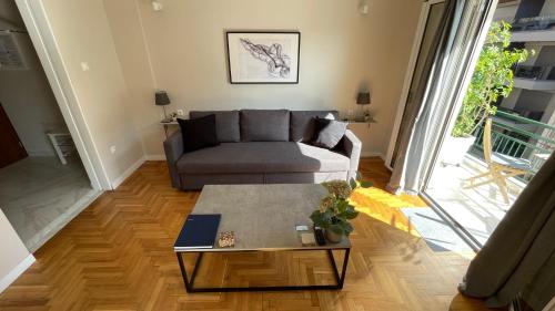 a living room with a couch and a table at 4 Newly Renovated Charming Apartments steps from Panormou Metro Station in Athens