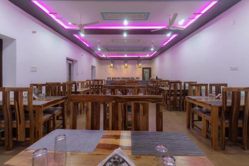 a room with wooden tables and chairs with purple lights at NK Desert Camp Jaisalmer in Sām
