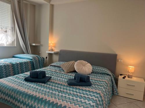 casa vacanze La Farfalla في كابو دورلاندو: غرفة نوم عليها سرير وفوط زرقاء