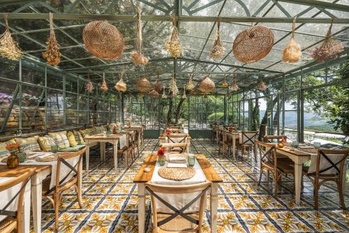 un restaurante con mesas y sillas en un invernadero en Borgo Vescine en Radda in Chianti