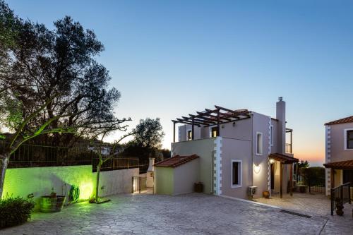 a villa with a courtyard in front of a building at Your Private Luxury Villa Mahin, Pool, Sea view, Rethymno in Kiriánna