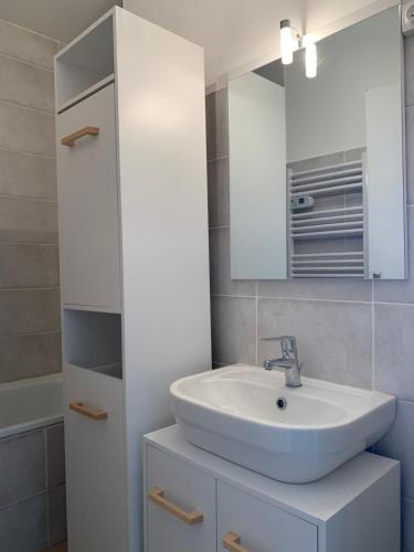 UvernetにあるPra Chauvet - Appartement 5 personnes Praloupの白い洗面台と鏡のあるバスルーム