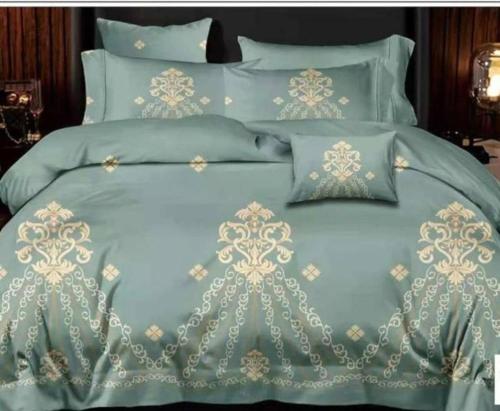 1 cama con edredón y almohadas azules en Calan Resdence, en Dodoma