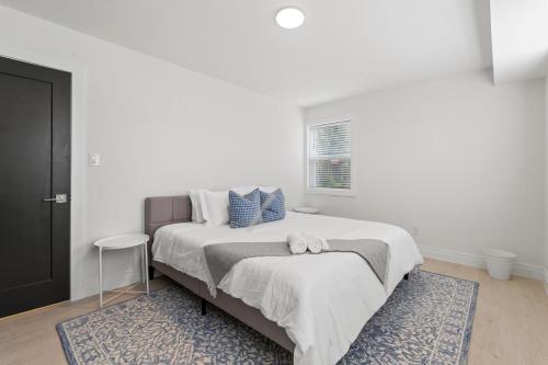 a white bedroom with a large bed with a blue rug at West Taylor Run Hotel in Alexandria