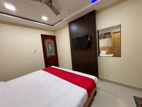 1 dormitorio con 1 cama y TV en la pared en STAYMAKER DV Residency, en Bhadrāvati