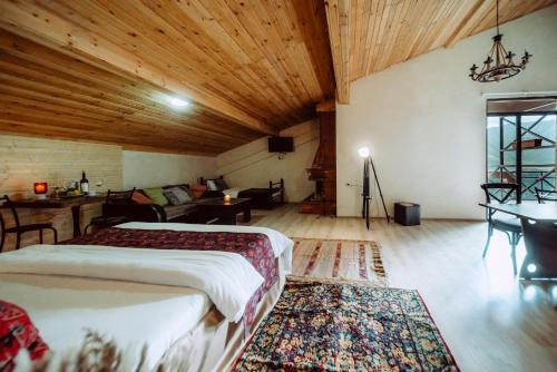a bedroom with a bed and a living room at Chalet Papa Basili in Gudauri