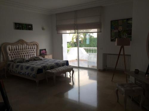 een slaapkamer met een bed en een glazen schuifdeur bij Villa Gammarth - Suite N°2 in Gammarth
