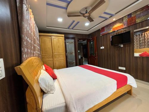 Schlafzimmer mit einem Bett und einem Deckenventilator in der Unterkunft STAYMAKER DV Residency in Bhadrāvati