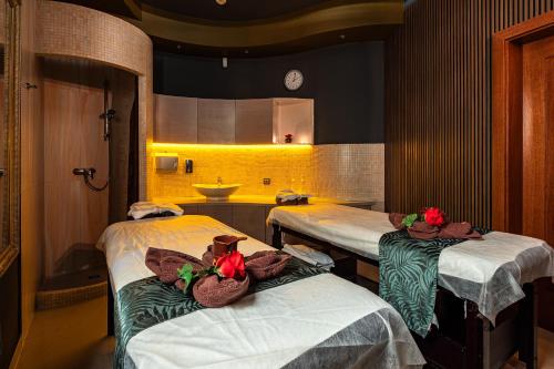 a hospital room with two beds with towels on them at Hotel Galicja Wellness & SPA in Oświęcim