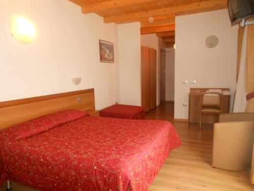 a bedroom with a red bed and a wooden floor at Hotel Montebaldina in San Zeno di Montagna