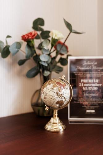 a globe on a table next to a vase with flowers at Munkedals Herrgård in Munkedal