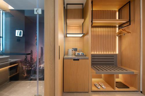 una cocina con una despensa a ras de suelo con una puerta de cristal en Rezen Longuu Hotel Guangzhou, en Guangzhou